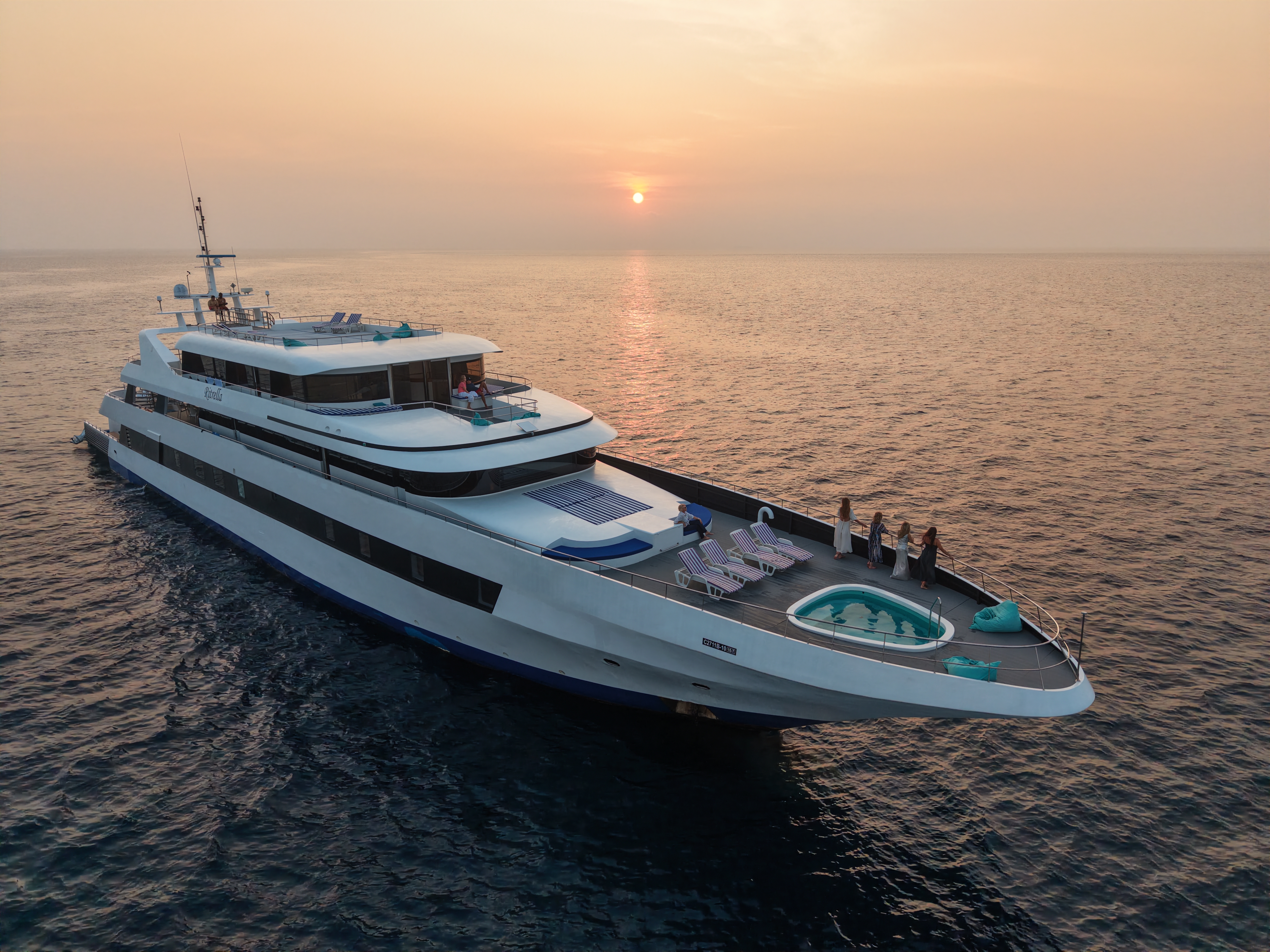 Private boat for hire with captain cruising turquoise water in the Maldives