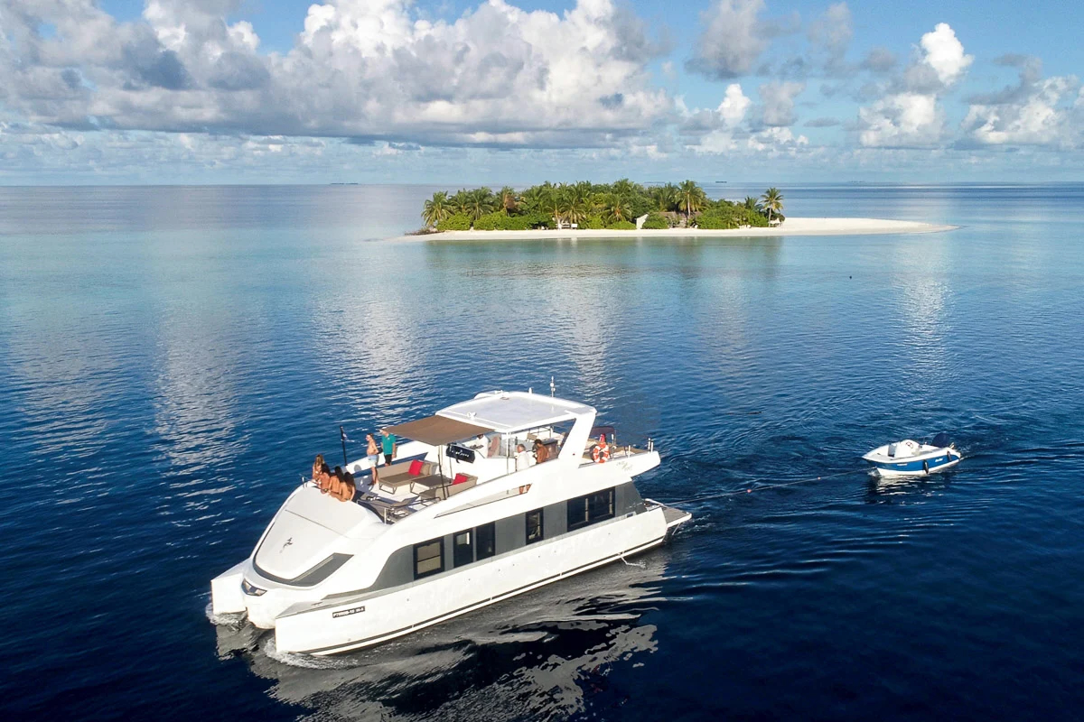 Luxury catamaran cruising turquoise water in the Maldives on a private day charter