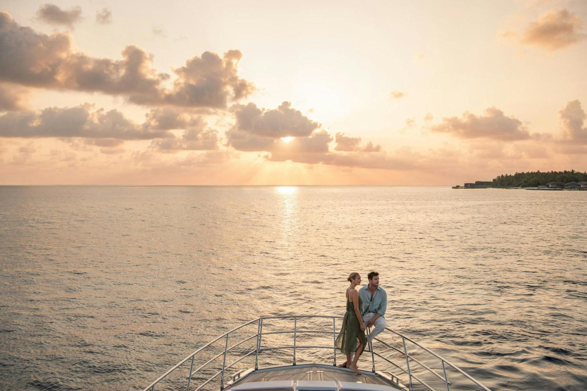 Private yacht at golden hour with dolphins in the Maldives